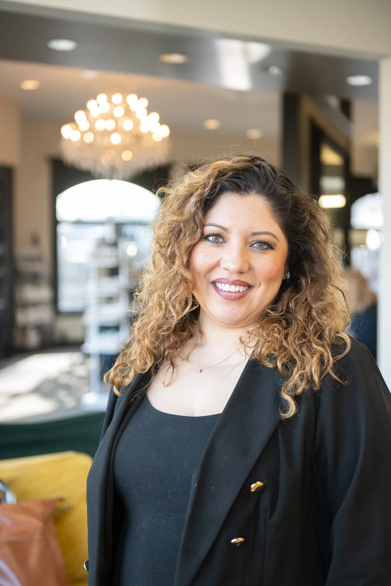 A woman with curly hair smiling indoors