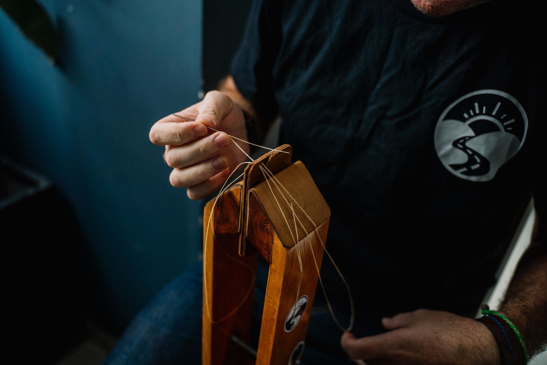 Artisan skillfully stitching a leather wallet using traditional hand tools.