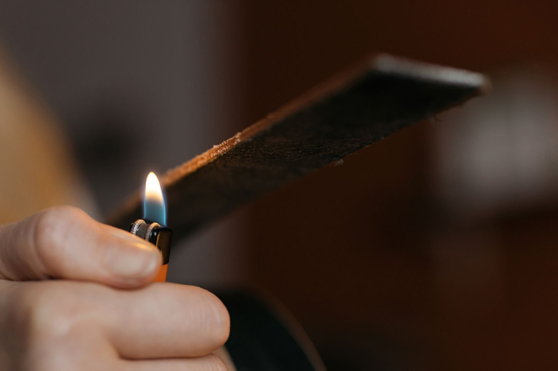 Artisan carefully burnishing a leather edge for crafting precision and finish.